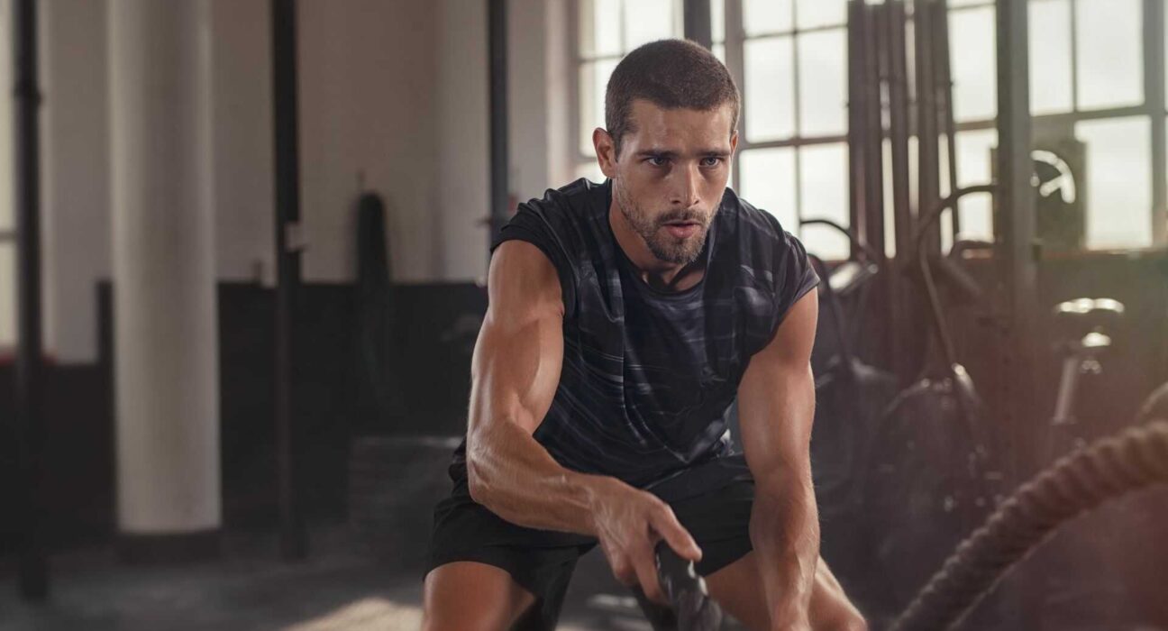 Mężczyzna trenujący na siłowni, ilustrujący aktywny styl życia i świadome podejście do suplementacji