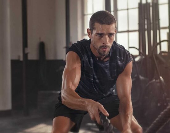 Mężczyzna trenujący na siłowni, ilustrujący aktywny styl życia i świadome podejście do suplementacji